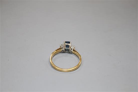 An 18ct, sapphire and diamond three stone ring, size N, gross weight 2.6 grams.